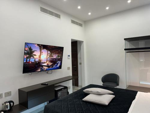 a bedroom with a bed with a flat screen tv on the wall at Relais Stibbert Florence in Florence