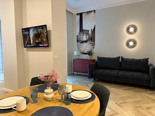 a living room with a table and a couch at NOWE !!! Apartamenty OFF PIOTRKOWSKA w Roosevelta Residence, Klimatyzacja, Wejście na KOD, WiFi, FV in Łódź