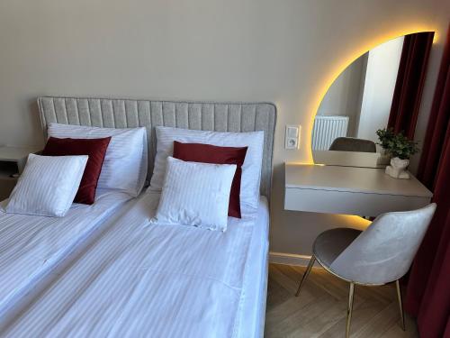 a bedroom with a bed with red pillows and a desk at NOWE !!! Apartamenty OFF PIOTRKOWSKA w Roosevelta Residence, Klimatyzacja, Wejście na KOD, WiFi, FV in Łódź