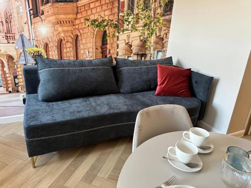 a living room with a blue couch and a table at NOWE !!! Apartamenty OFF PIOTRKOWSKA w Roosevelta Residence, Klimatyzacja, Wejście na KOD, WiFi, FV in Łódź