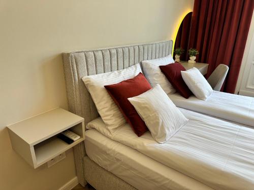 a bedroom with a bed with red and white pillows at NOWE !!! Apartamenty OFF PIOTRKOWSKA w Roosevelta Residence, Klimatyzacja, Wejście na KOD, WiFi, FV in Łódź