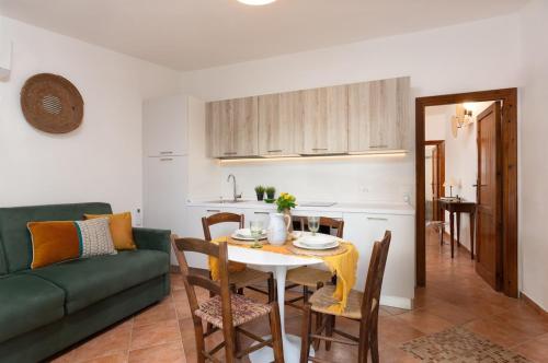 a living room with a table and a green couch at Su Scannu - Stylish Beach apartment with Lounge terrace in Quartu Sant'Elena