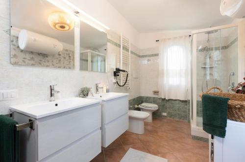 a white bathroom with a sink and a toilet at Su Scannu - Stylish Beach apartment with Lounge terrace in Quartu Sant'Elena