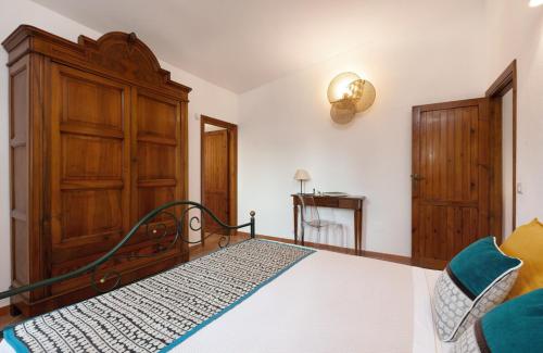 a bedroom with a bed and a wooden cabinet at Su Scannu - Stylish Beach apartment with Lounge terrace in Quartu Sant'Elena