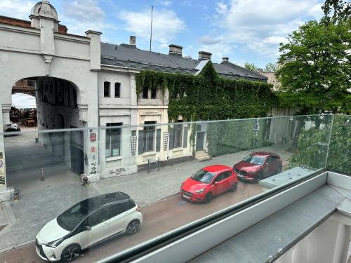 two cars parked on a street in front of a building at NOWE !!! Apartamenty OFF PIOTRKOWSKA w Roosevelta Residence, Klimatyzacja, Wejście na KOD, WiFi, FV in Łódź