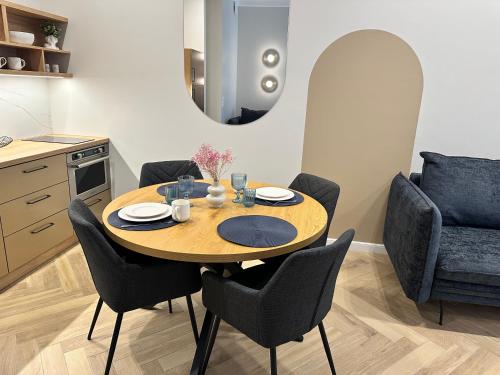 a dining room with a table and chairs and a mirror at NOWE !!! Apartamenty OFF PIOTRKOWSKA w Roosevelta Residence, Klimatyzacja, Wejście na KOD, WiFi, FV in Łódź