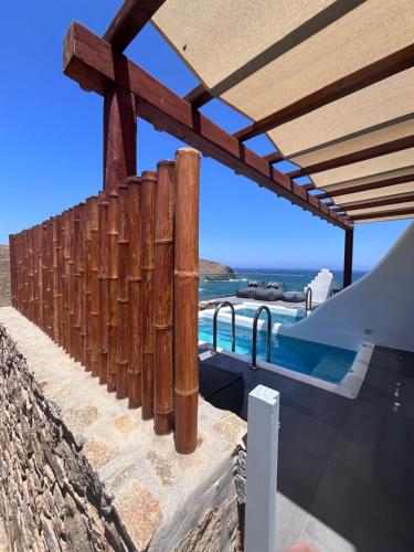 a wooden fence next to a swimming pool at Merchia Bay Villas Mykonos in Merchia Beach