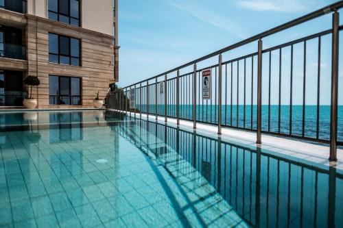 a swimming pool with a view of the ocean at Cabacum Pleasure Beachfront Apartments in Varna City