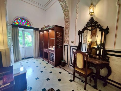 a room with a mirror and a chair in it at Hotel Narain Niwas Palace in Jaipur