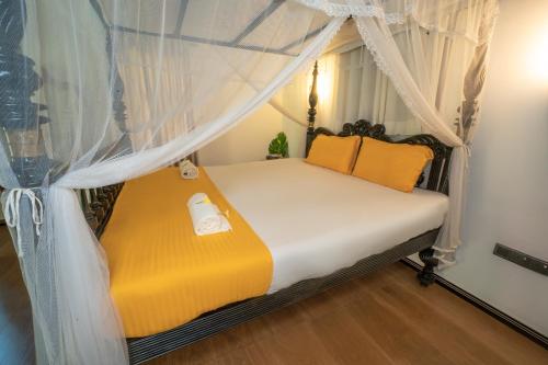 a bedroom with a bed with a canopy at Araliya Gardens Hotel in Hikkaduwa
