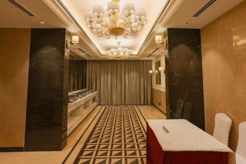 a room with a chandelier and a table and chairs at Pride Hotel Pune in Pune