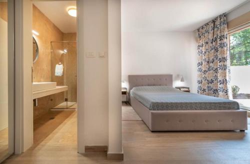 a bedroom with a bed and a bathroom with a tub at Apartment Marta in Ljuta