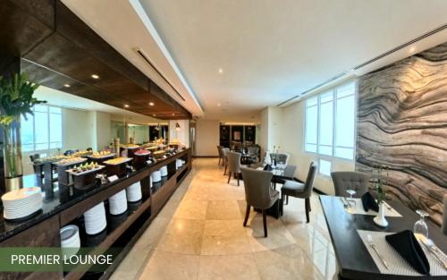 a restaurant with tables and chairs in a building at Acacia Hotel Davao in Davao City
