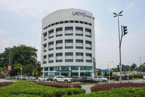 a uso building with cars parked in a parking lot at Ukiyo Hotel by manatidur in Petaling Jaya
