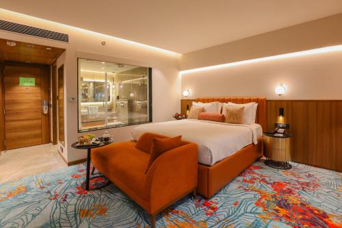a bedroom with a large bed and a chair at Pride Hotel Pune in Pune