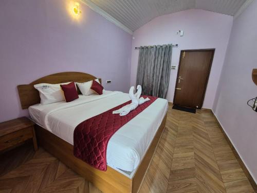a bedroom with a bed with a towel animal on it at Sharma Jee Farm House Yercaud in Yercaud