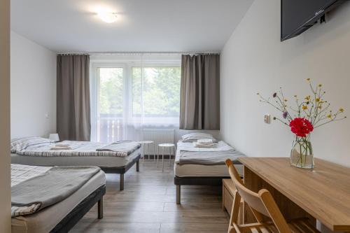 a room with three beds and a table at DIUNA Beskidy - Korbielów in Korbielów
