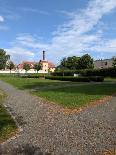 a road in front of a house with a building at Zámek Spálené Poříčí in Spálené Poříčí