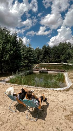 two people laying in a lawn chair on the beach at Starodawna Chata - Dziad in Zamość