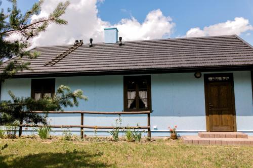a blue house with a porch and a window at Starodawna Chata - Dziad in Zamość