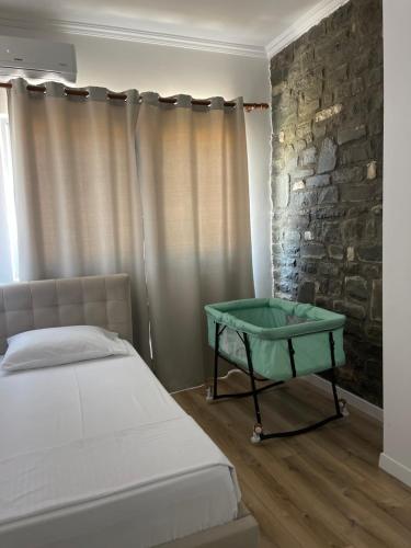 a bedroom with a bed and a stone wall at Kutal Park Inn Hotel in Përmet