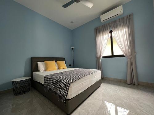 ein Schlafzimmer mit einem Bett mit gelben Kissen und einem Fenster in der Unterkunft 189 Landed HomeStay Johor Bahru in Kampong Saleng