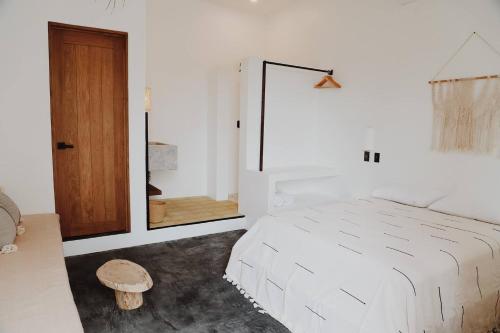 a white bedroom with a bed and a mirror at Casa Ohma La Punta in Brisas de Zicatela