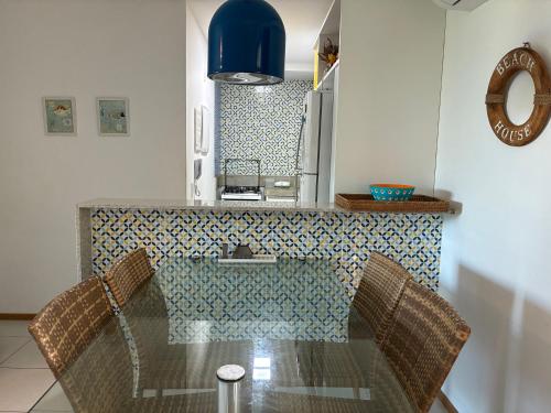 a kitchen with a glass table with two chairs at Muro Alto Flat Nui Supreme in Porto De Galinhas