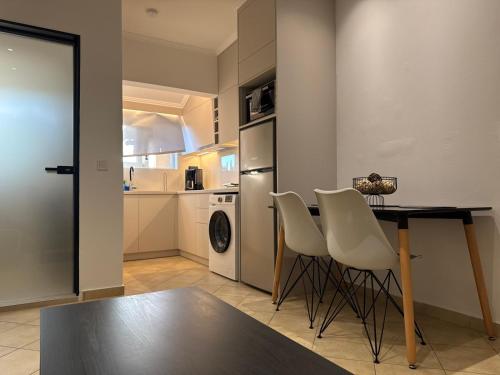 a kitchen with a table and chairs and a refrigerator at Alex Apartment Suites in Virós