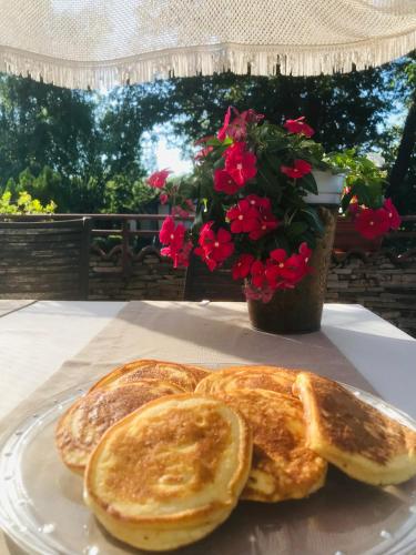 スモリャンにあるHotel Smilenの皿の上に置かれた2枚のパンと花瓶の花