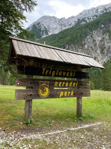 a wooden sign with a roof on top of it at Apartma Confine in Rateče