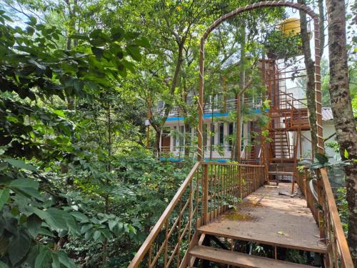 a wooden bridge in the middle of a forest at Sharma Jee Farm House Yercaud in Yercaud