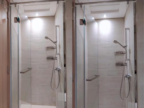 a bathroom with a shower with glass doors at Pet Free Studio Apartment Close Downtown Fast Wi-fi in Dubai