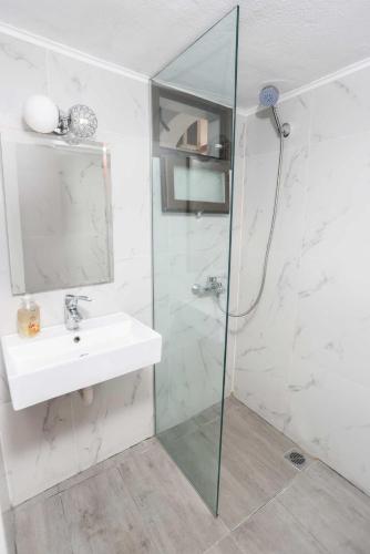 a bathroom with a sink and a glass shower at Stratos Angels apartments in Pefkohori