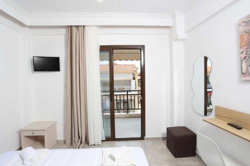 a white room with a bed and a window at Stratos Angels apartments in Pefkohori