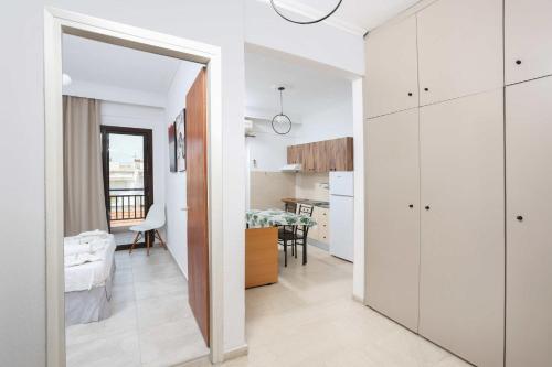 a white apartment with a kitchen and a dining room at Stratos Angels apartments in Pefkohori