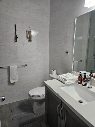 a white bathroom with a toilet and a sink at Cozy Studio in TCI in Providenciales