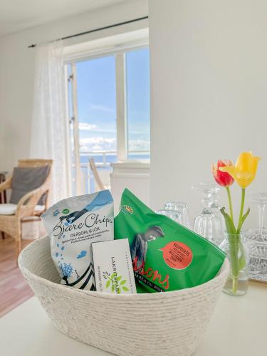 a basket filled with snacks and books on a table at Pensionat Strandgården in Mölle