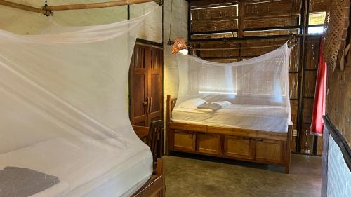 a bedroom with two beds with a mosquito net at Sa Sa Lao in Luang Prabang