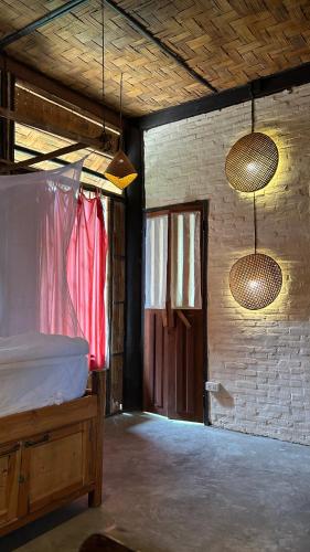 a bedroom with a bed and two lights and a door at Sa Sa Lao in Luang Prabang