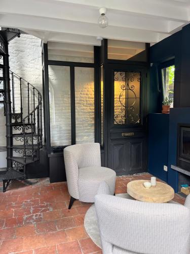 a living room with two chairs and a table at La Très Petite Tour in Nivelles