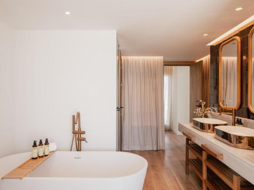 a bathroom with two sinks and a large tub at ME Marbella by Meliá in Marbella