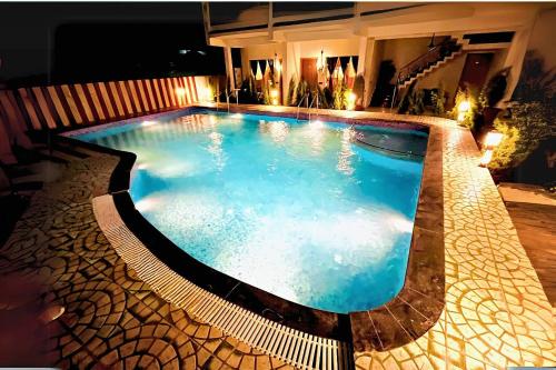 una grande piscina con acqua blu di notte di Three Heavens Corbett a Ramnagar
