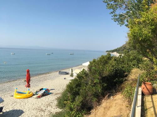 a beach with boats and umbrellas and the ocean at Heavenly place in Possidi