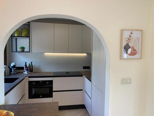 an archway in a kitchen with white cabinets at Villa Mariposa in Calpe