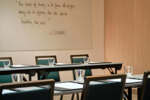 a room with tables and chairs and a whiteboard at AC Hotel by Marriott Nice in Nice