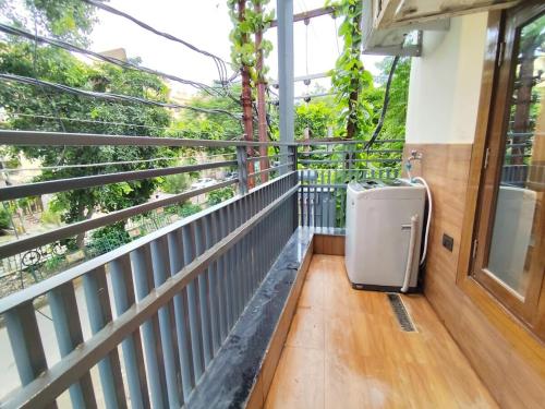 una valigia appoggiata sul portico di un balcone di Homlee-Diamond 2BHK Lift-Parking-Max Vaishali a Ghaziabad