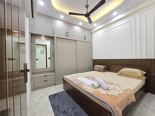 una camera da letto con un letto e un ventilatore a soffitto di Homlee-Diamond 2BHK Lift-Parking-Max Vaishali a Ghaziabad
