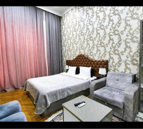 a hotel room with a bed and a chair at Prime Boutique Hotel in Baku