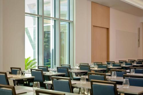 a dining room with tables and chairs and windows at AC Hotel by Marriott Nice in Nice